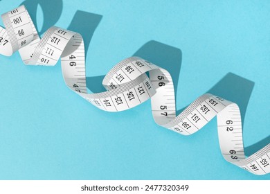 Measuring tape on blue background. Weight or length concept