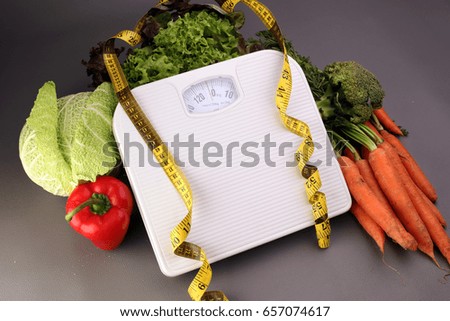 Measuring tape on white weight scale and vagetables. Dieting weightloss slim down concept.