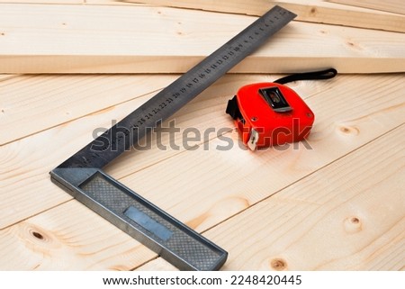 A measuring tape and a square. Tools for measuring. Joiner's (carpenter's) workshop. Close-up.