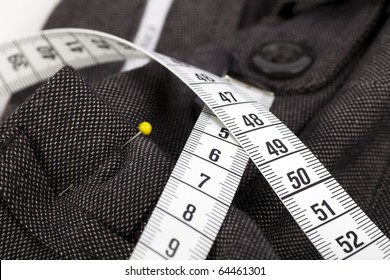 Measuring tape and trousers about to be altered.
