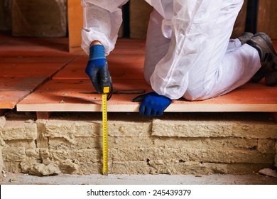 Measuring The Thickness Of Thermal Insulation - Worker Hands With Tape Measure