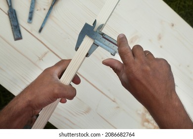 Measuring with vernier calipers (callipers). Joiner's (carpenter's) tool. Woodworking instrument. Close-up. - Shutterstock ID 2086682764