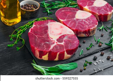 meat beef veal shank slices meat for Osso Buco cooking on dark black wooden background. Ingredients for beef meat Osso Buco sage leaves, thyme, rosemary, pepper, salt, pepper, vegetable oil - Powered by Shutterstock