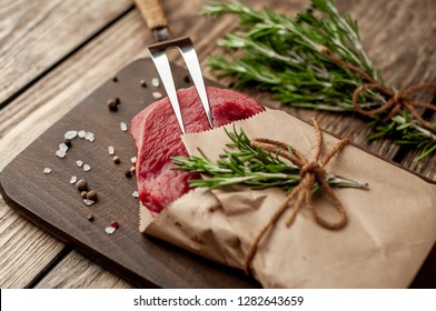 
Meat From A Butcher Shop, Wrapped In Paper. A Piece Of Beef On A Wooden Background