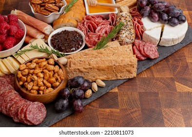 A Meat Cheese And Fruit Charcuterie Board On A Wooden Butcher Block