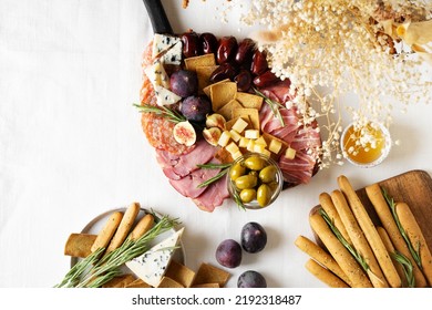 Meat, cheese and snackes plate, board and grissini with dry flowers bouquet, on white background, flat lay, top view, - Shutterstock ID 2192318487
