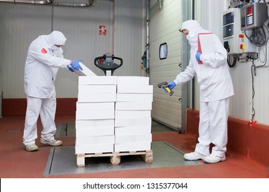 Meat cutting room workers weighing a pallet of boxes at the loading dock