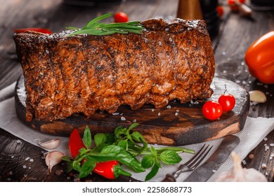 Meat delicacy, boiled pork with layers of lard, whole or sliced on a kitchen cutting board, spices and vegetables, dark and moody, clouseup on a black wooden isolated background, top - Shutterstock ID 2258688773