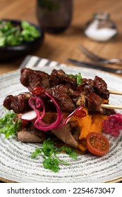 Meat dish, stake, kebab on a wooden table with salad - Shutterstock ID 2254673047