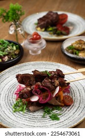 Meat dish, stake, kebab on a wooden table with salad - Shutterstock ID 2254673061