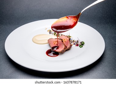 Meat fillet covering with sauce on a white plate - Shutterstock ID 1637878171