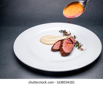Meat fillet covering with sauce on a white plate - Shutterstock ID 1638534181