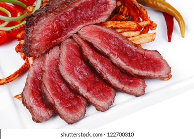 Meat Food : Rare Beef On Potato Chips With Pepper And Tomatoes Over Plate Isolated On White Background