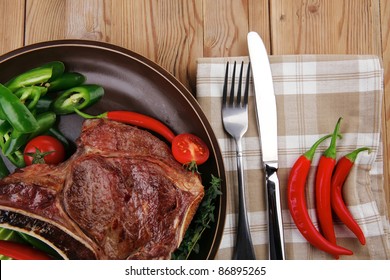 Meat Food : Roast Rib On Dark Dish With Thyme Pepper And Tomato On Wooden Table