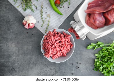 Meat grinder with fresh forcemeat on kitchen table