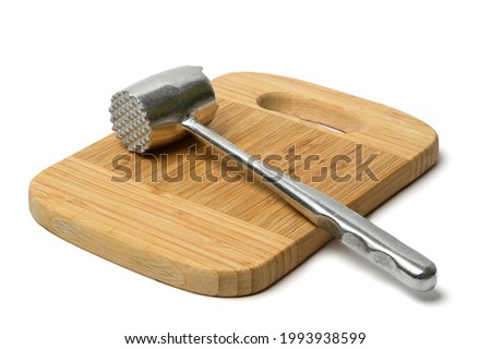 The meat hummer is on wooden bamboo cutting board. This is white background. This is isolated view of chopping board with hummer.