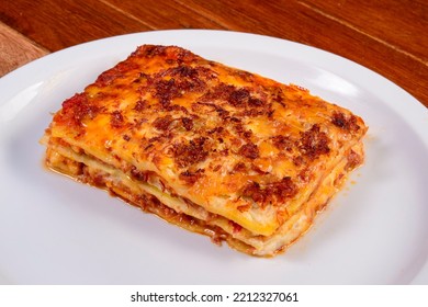 Meat Lasagna Slice On White Plate Over Wooden Table. Lasagna Delivery.