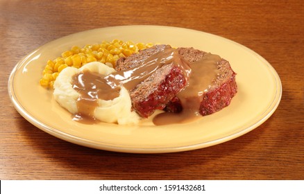 Meat Loaf With Mashed Potatoes And Gravy With Corn On Yellow Plate.