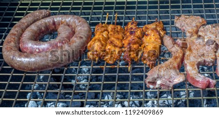 Meat on the grill in a traditional South African braai image with copy space in landscape format