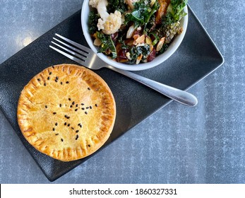 Meat Pie With Cauliflower And Kale Side Salad On A Square Plate