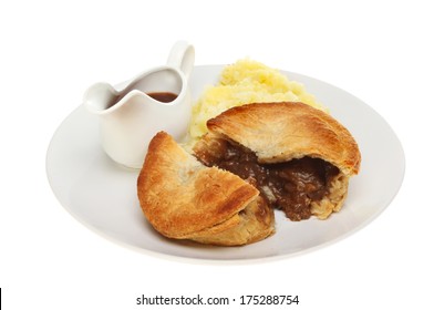 Meat Pie Mashed Potato And Gravy In A Jug On A Plate Isolated Against White