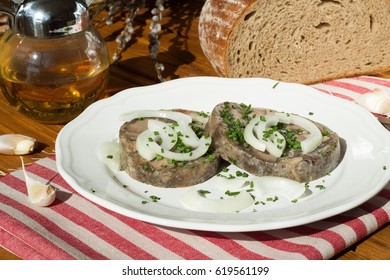 Meat from a pig's  head that is cooked and pressed in a pot with jelly. Brawn  as usually served in the Czech Republic. Tla?enka/ Brawn slices on a plate - Shutterstock ID 619561199