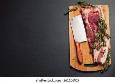 Meat pork fresh. Raw meat on cutting board. Rosemary spice and meat. Axe and meat pig. Fat piece - Shutterstock ID 261186029