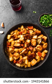 Meat and potato stew on black, top view, copy space. Homemade pork meat hot meal in cast iron pan and red wine. - Shutterstock ID 1943141866