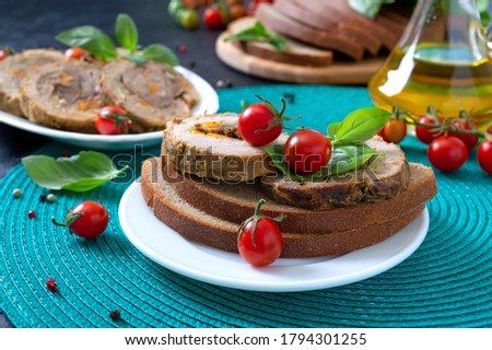 Meat rolls on rye bread with cherry tomatoes and basil. Tasty and healthy breakfast.