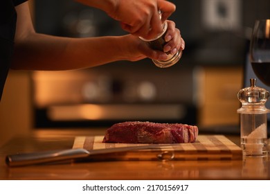 Meat should always be well seasoned. Shot of a woman seasoning a piece of steak for dinner. - Shutterstock ID 2170156917