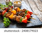 Meat skewers - grilled meat with vegetables on wooden background 