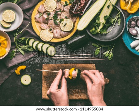 Similar – Image, Stock Photo Female hands making chicken skewers with vegetables for grilling