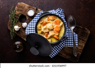 Ragoût de viande, filet de poulet en sauce avec carotte dans un pot en fonte, vue de dessus