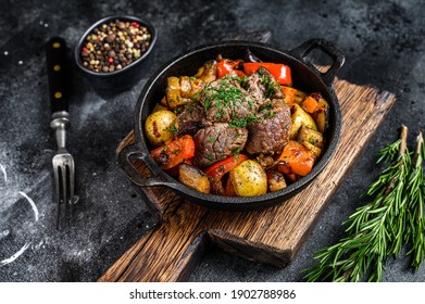 Meat stew in cooking pot on dark rustic cutting board. Black background. Top view. - Powered by Shutterstock