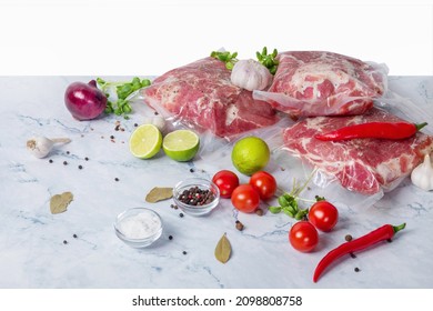 Meat in vacuum with vegetables and spices isolated on white background.