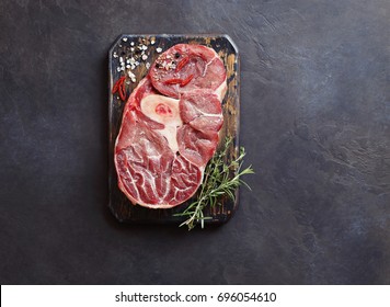 Meat.Raw veal cut with herbs and spice ready to cook on rustic wooden cutting board. Dark background - Powered by Shutterstock