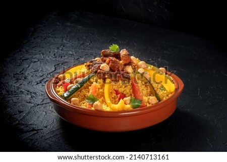 Meat and vegetable couscous, festive Arabic food with chickpeas, on a dark background