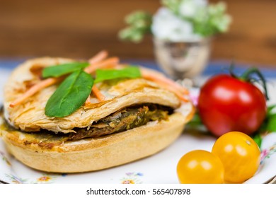 Meat and vegetable pie serving on the wooden table 