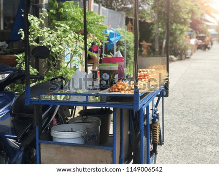 Meatball grilled street food with spicy sauce on cart in small city