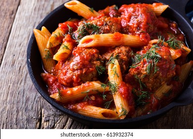 Meatball Penne Pasta With Spicy Tomato Sauce And Dill In Cast Iron Pan On Rustic Wooden Table 