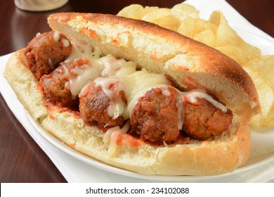 A meatball sandwich with mozzarella cheese and potato chips