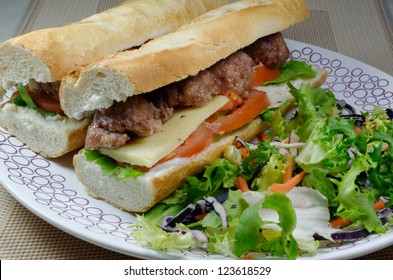 Meatball Sandwich On A White Plate With Fresh Salad