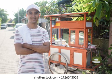 Meatball Street Food Vendor. Asian Man Selling Bakso By Walking And Pushing Down The Food Carts