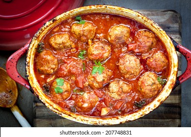 Meatballs Casserole In Red Iron Crock Pot.