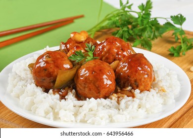 Meatballs Stewed In Sauce Of With Green Bell Pepper, Onion, Soy Sauce, Chinese Cooking Wine, Cashew Nuts And Spices Served On Basmati Rice On White Dish On Wooden Board, Close-up