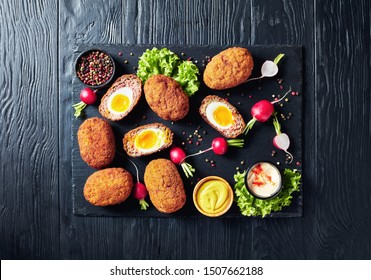 Meatballs Stuffed With Soft Boiled Eggs, Scotch Eggs Served With Radish, Mayonnaise And Mustard On A Black Stone Plate, View From Above