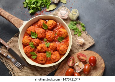 Meatballs in sweet and sour tomato sauce with spices served in a frying pan on dark background . Top view  - Shutterstock ID 1475721347