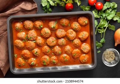 Meatballs With Tomato Sauce In Baking Dish Over Dark Stone Background. Top View, Flat Lay