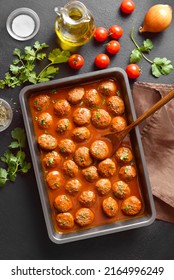 Meatballs With Tomato Sauce In Baking Dish Over Dark Stone Background. Top View, Flat Lay