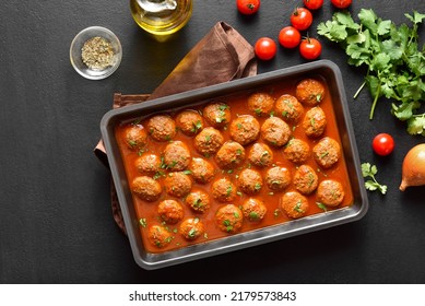 Meatballs With Tomato Sauce In Baking Dish Over Dark Stone Background. Top View, Flat Lay